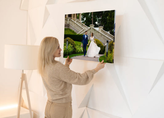 femeie care dispune un tablou canvas personalizat pe un perete din locuinta