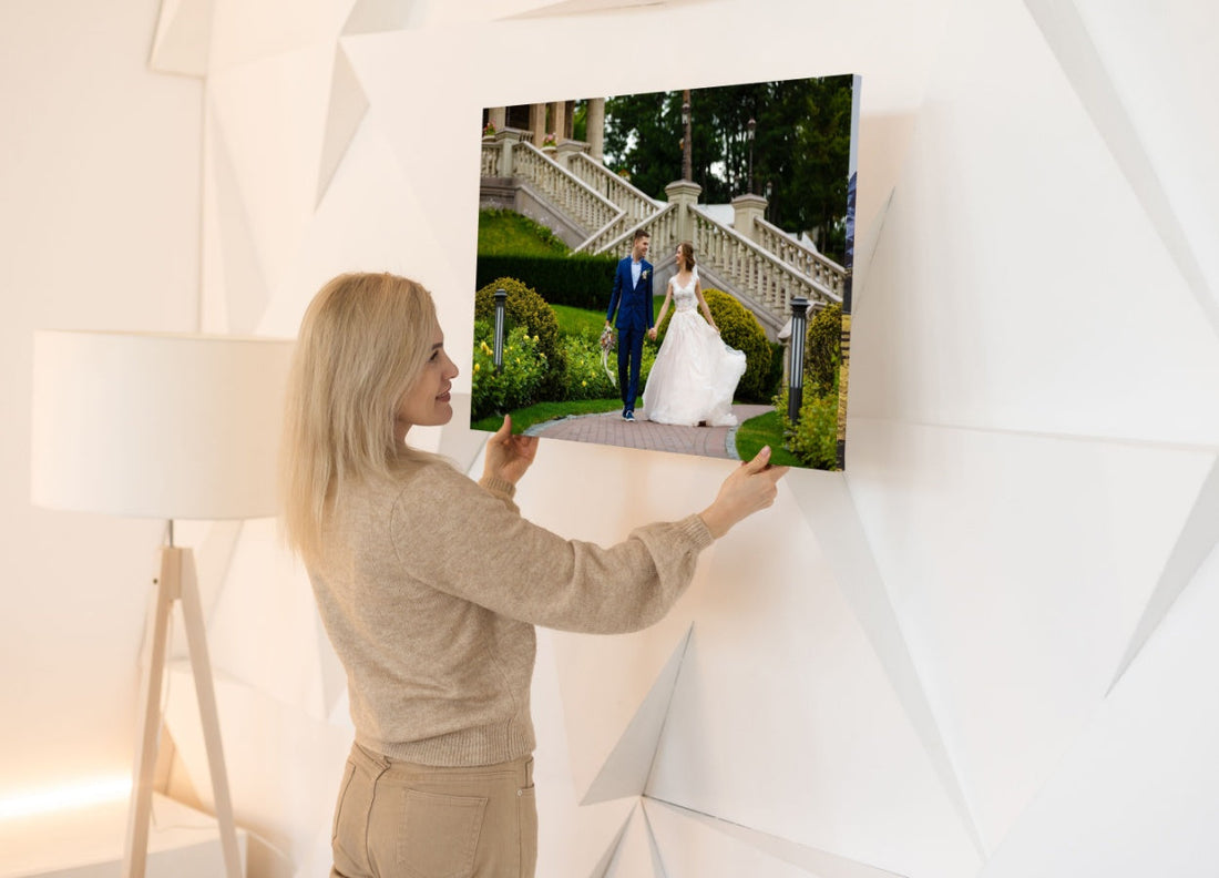 femeie care dispune un tablou canvas personalizat pe un perete din locuinta