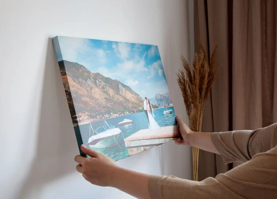 femeie care dispune pe perete tablouri canvas